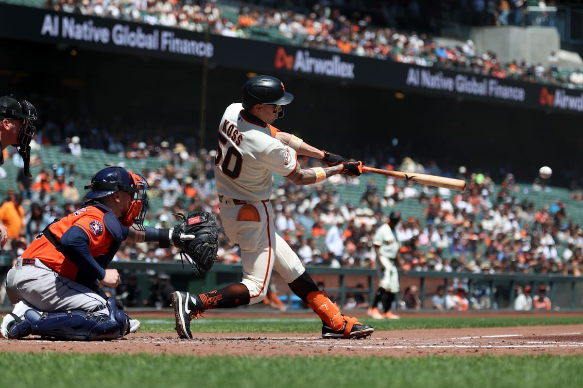 Christian Koss, de los Gigantes de San Francisco, conecta un sencillo delante del catcher boricua Ch