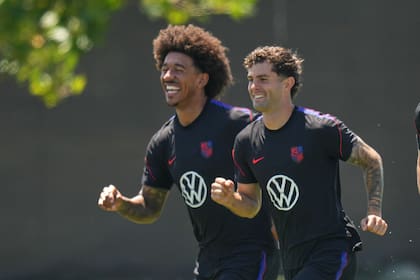 Christian Pulisic (derecha) y Chris Richards, a pura sonrisa y exigencia en un entrenamiento. (AP Foto/Andre Penner)