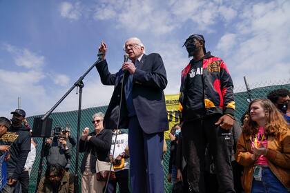 Christian Smalls, presidente del Sindicato de Trabajadores de Amazon, acompaña al senador Bernie Sanders, quien apoya al sindicato en un mitin frente a una instalación de Amazon en Staten Island, Nueva York, el domingo 24 de abril de 2022. (Foto AP/Seth Wenig)