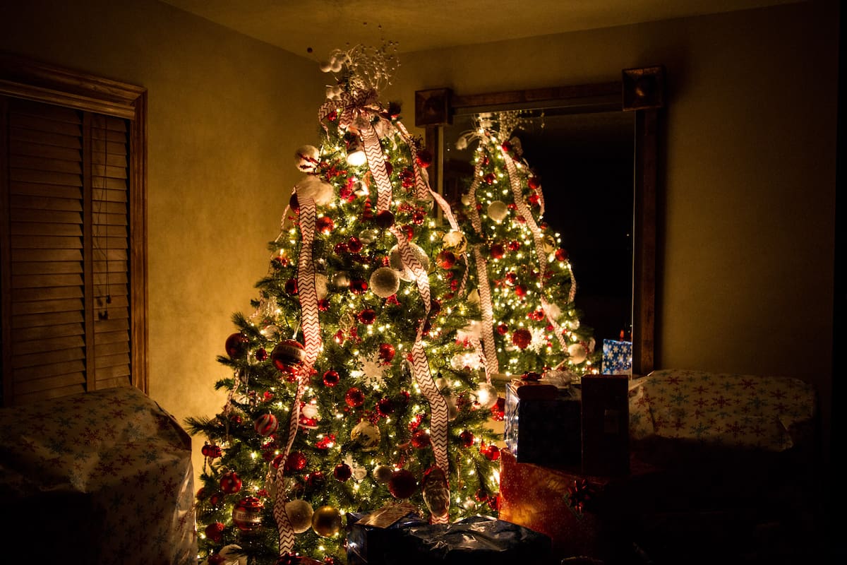 Christmas tree at night surrounded by presents