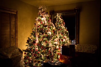 Christmas tree at night surrounded by presents