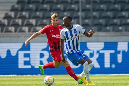 Christopher Lenz del Eintracht Frankfurt pelea por el balón con Dodi Lukebakio del Hertha Berlín en el encuentro de la Bundesliga el sábado 13 de agosto del 2022. (Christophe Gateau/dpa via AP)