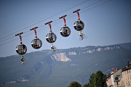 Un grupo de ciclistas cuelga bajo los teleféricos de Grenoble Bastille