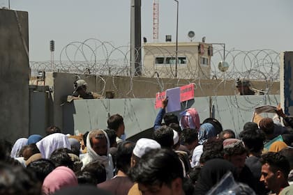 Cientos de personas se aglomeran en un retén de control de la evacuación en el perímetro del aeropuerto de Kabul, Afganistán, jueves 26 de agosto de 2021. (AP Foto/Wali Sabawoon)