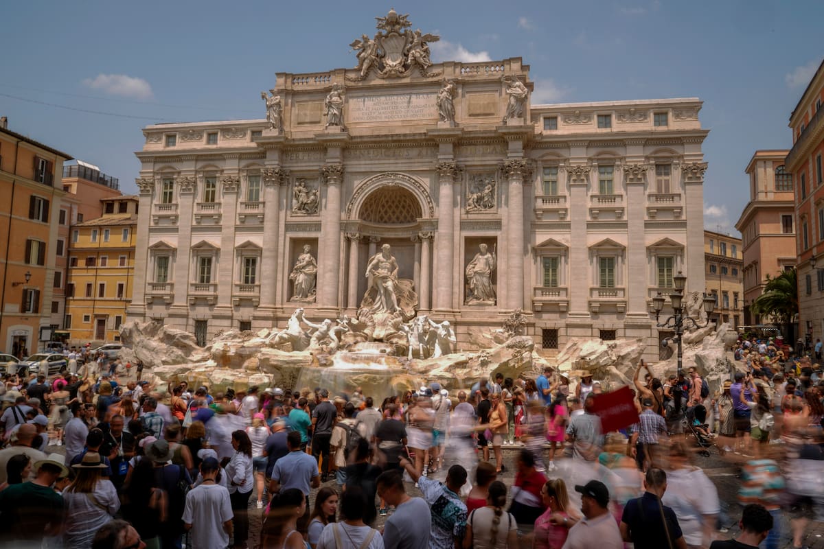 Cientos de turistas visitan la Fuente de Trevi en Roma, el viernes 30 de junio de 2023. Las multitudes colman el Coliseo, el Louvre, la Acrópolis y otras atracciones importantes este verano, mientras el turismo supera los récords de 2019 en algunos de los destinos más populares de Europa. Luego de que los europeos permitieron la recuperación del sector turístico el año pasado, el repunte de este verano es liderado en gran medida por los estadounidenses, beneficiados por un dólar fuerte y, en algunos casos, por sus ahorros durante la pandemia. (AP Foto/Andrew Medichini)