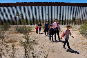 Cinco integrantes de una familia que aseguran ser originarios de Guatemala, y un hombre que dice ser de Perú, vestido con camisa rosa, atraviesan el desierto después de cruzar el muro fronterizo, el 29 de agosto de 2023, en el sector Tucson de la frontera entre México y Estados Unidos, en el Monumento Nacional del Cactus de Tubo de Órgano, cerca de Lukeville, Arizona. (AP Foto/Matt York, Archivo)