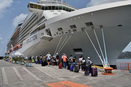 Ciudadanos británicos, canadienses y estadounidenses abordan el buque crucero Reflection, de la línea Royal Caribbean, en la isla caribeña de San Vicente