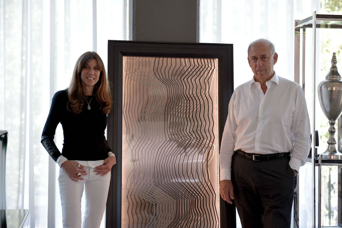 Claudia Fontenla y Roberto Fontenla junto al panel energético en la fábrica Fontenla Furniture