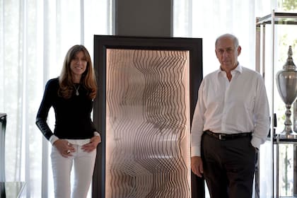 Claudia Fontenla y Roberto Fontenla junto al panel energético en la fábrica Fontenla Furniture