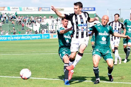 Claudio Riaño, autor del 1-0 de Central Córdoba a Sarmiento, intenta pasar entre Bazzana y Mancinelli