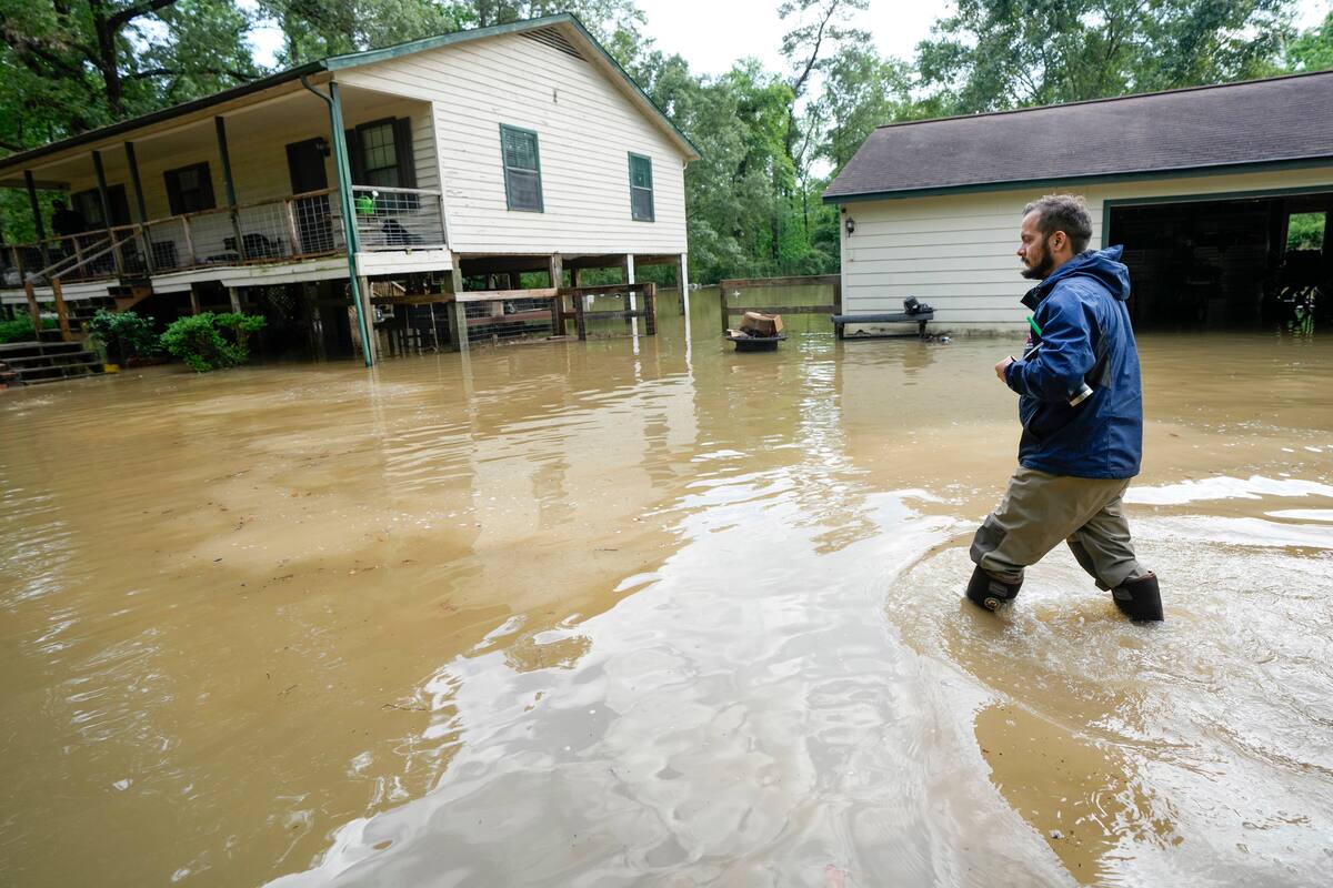 Clayton Lobue camina entre las aguas mientras se dirige a su casa, el viernes 3 de mayo de 2024, en New Caney, Texas. (Brett Coomer/Houston Chronicle vía AP); este 14 de junio rige una alerta por posible desarrollo ciclónico en el suroeste del Golfo de México podría llevar abundantes lluvias al sur de Texas