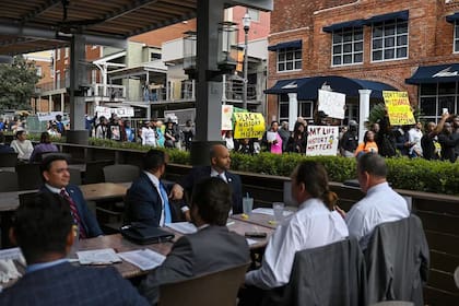 Clientes de restaurantes observan cómo los manifestantes protestan por la decisión del estado de no aprobar un nuevo curso AP sobre historia afroamericana en febrero en Tallahassee, Florida