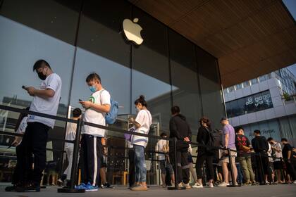 Clientes hacen fila fuera de una Apple Store antes de que abra para el primer día de ventas del iPhone 14, el 16 de septiembre de 2022, en Beijing. (AP Foto/Mark Schiefelbein, Archivo)
