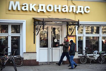 Clientes ingresan a un restaurante McDonald's en Moscú. El gigante estadounidense de comida rápida, que cerró sus tiendas en Rusia a principios de marzo, anunció el 16 de mayo de 2022 que se retiraría del país y vendería todas sus operaciones en respuesta a la invasión rusa de Ucrania. (Photo by AFP)