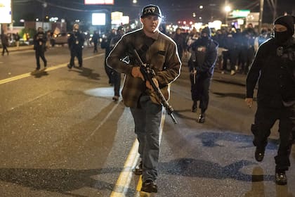 Clima de guerra: Chandler Pappas, miembro del grupo Orgullo patriota, con un rifle de asalto mientras camina entre una multitud de manifestantes de Black Lives Matter en Vancouver, Washington