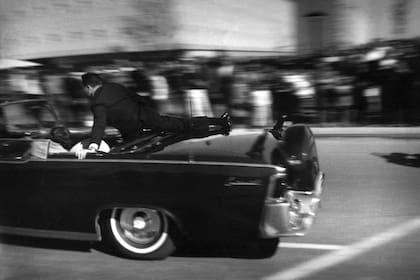 Clint Hill, en el momento en que salta sobre el coche presidencial y trata de salvar a JFK