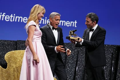Clooney recibió con emoción el galardón de la mano de Pietrangelo Buttafuoc, el presidente de la Biennale Foundation de Venecia y la actriz Laura Dern