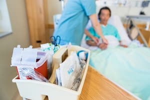 Close up of IV cart with nurse and patient in background