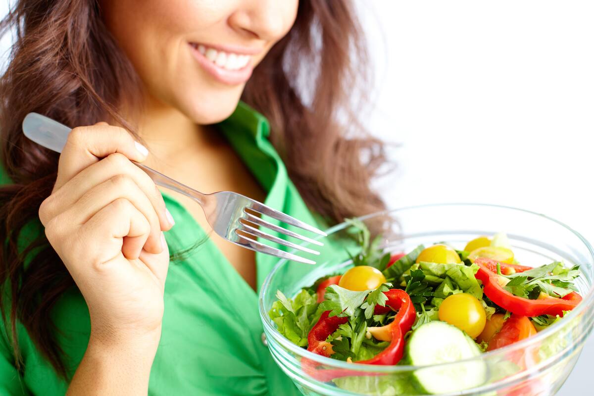Close-up of pretty girl eating fresh vegetable salad
