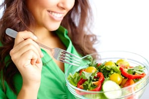 Close-up of pretty girl eating fresh vegetable salad