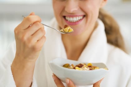 Closeup on happy woman in bathrobe having healthy breakfast