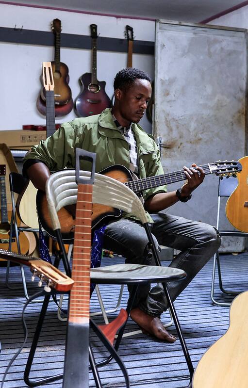 Clovis Tchoufack posa con guitarras en su taller de Duala