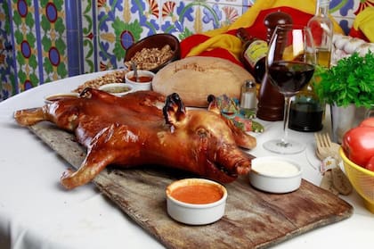 Cochinillo de campo horneado, con papas, batata y ensalada. La mitad cuesta $65.000 y, entero, $90.000.