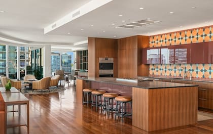 Cocina de concepto abierto con muebles de madera, encimeras de piedra