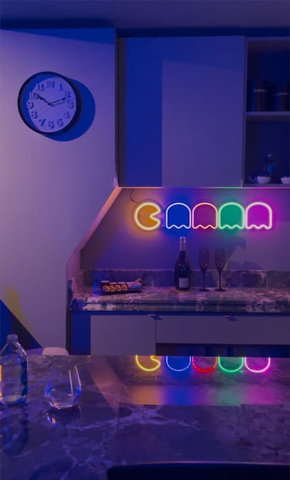 El espíritu lúdico está presente en todo el espacio, incluyendo la cocina, donde un aplique de neón que alude al "Pac Man" agrega tonalidad colorida a las luces bajas.