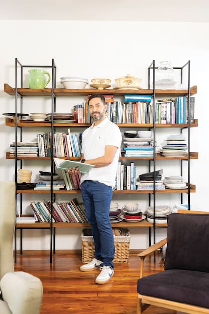 Coco posa delante de su biblioteca donde, obviamente, no faltan los libros de cocina.