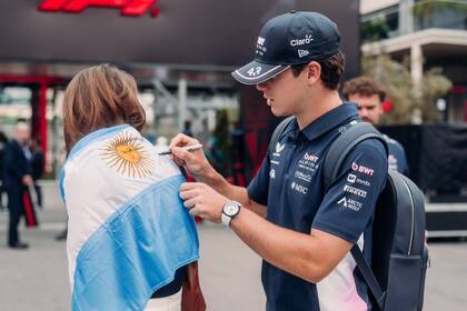 Colapinto firma la bandera de una fan antes de afrontar la primera práctica libre en Bakú
