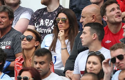 Coleen Rooney, con vestido rojo, sentada delante de Rebekah Vardy, con camiseta blanca, durante un partido de la selección de Inglaterra por la Eurocopa de 2016.