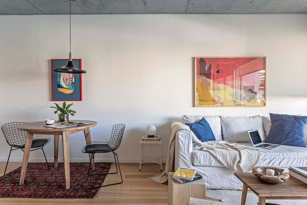 Colgados en la misma línea los cuadros sirven para identificar dos espacios diferentes en un ambiente integrado.