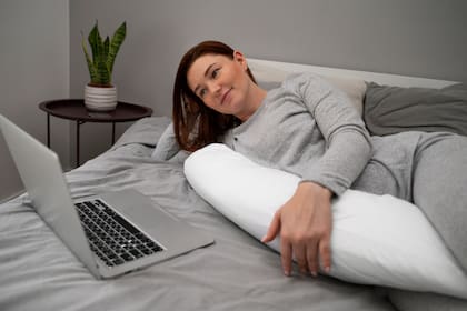 Colocar una almohada entre las piernas al dormir puede ayudar a mejorar la postura