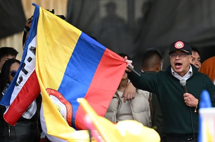 El presidente colombiano, Gustavo Petro, ondea una bandera nacional mientras pronuncia un discurso durante una manifestación del Día del Trabajo en Bogotá el 1 de mayo de 2024