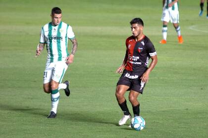 Martín Payero, de Banfield, persigue a Rafael Delgado, defensor de Colón