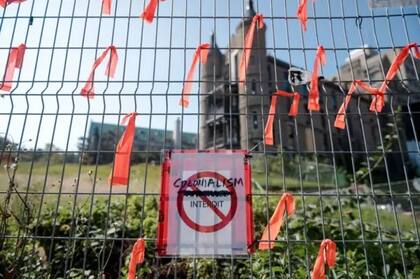 "Colonialismo prohibido", se lee en una cartel pegado en la valla frente al antiguo Royal Victoria Hospital de Montreal durante una protesta para recordar las atrocidades cometidas durante décadas en Canadá contra las naciones originarias