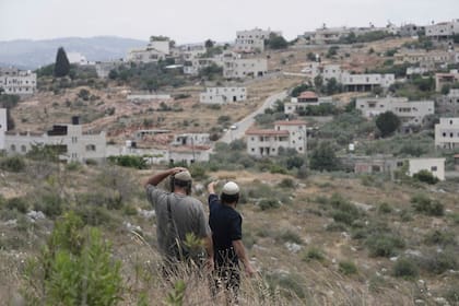 Colonos israelíes en las afueras del asentamiento de Bruchin, en Cisjordania, el 15 de mayo de 2025. (AP Foto/Maya Alleruzzo)