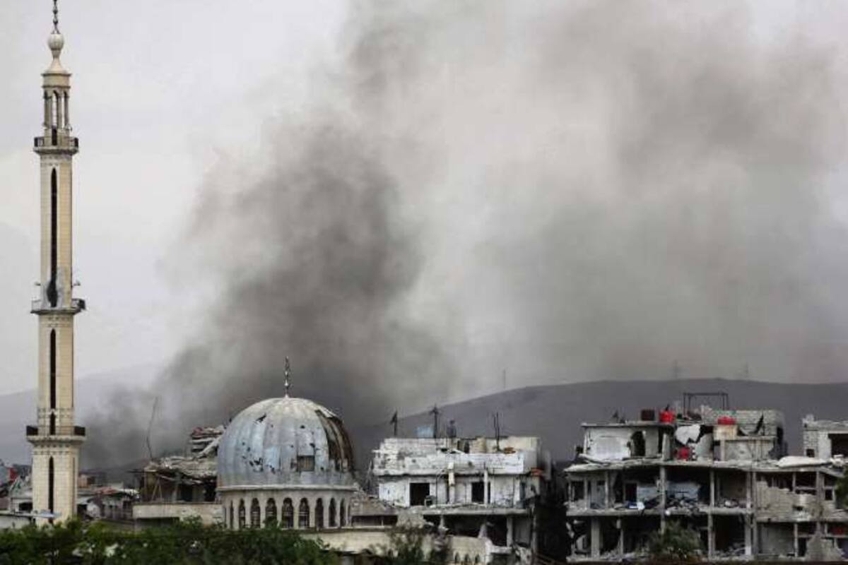 Columnas de humo asoman por encima de los edificios en el bastión rebelde de Ghouta Oriental