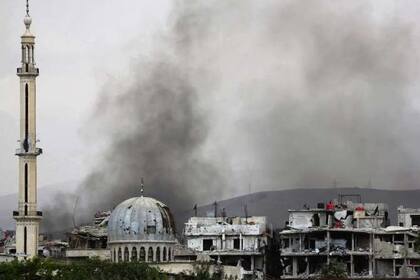 Columnas de humo asoman por encima de los edificios en el bastión rebelde de Ghouta Oriental