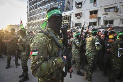 Combatientes de las Brigadas Qassam, el ala militar de Hamas, controlan a la multitud en la ciudad de Gaza