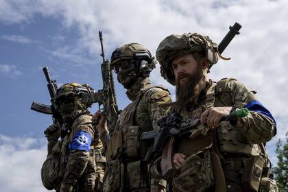 Combatientes del Cuerpo de Voluntarios Rusos se encuentran en la parte superior de un vehículo blindado durante una conferencia de prensa cerca de la frontera entre Ucrania y Rusia en la región de Sumy, Ucrania, el 24 de mayo de 2023.