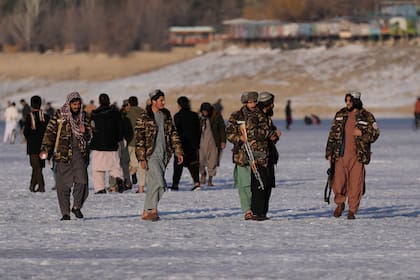 Combatientes del Talibán caminan sobre el Lago Qargha congelado, cerca de Kabul, Afganistán, el viernes 11 de febrero de 2022. (AP Foto/Hussein Malla)