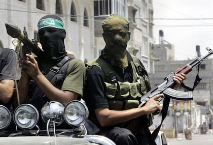 Combatientes palestinos de Hamas marchan en una camioneta con sus armas durante el funeral del extremista Emad Abu Kados, que murió durante enfrentamientos con hombres armados del movimiento Fatah en el vecindario Jeque Radwan, el 13 de junio de 2007, en la Ciudad de Gaza