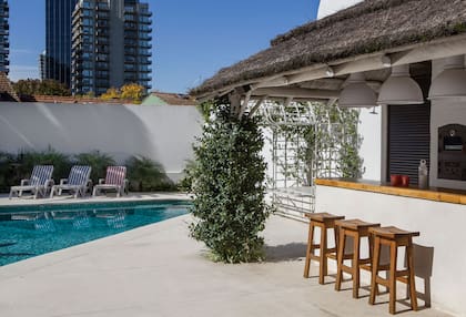 Además de la pileta, el jardín posterior tiene quincho con barra, parrilla, baño y vestuario.