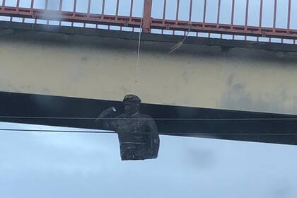 Una parte de la estatua de Chávez quemada quedó colgada de un puente en San Félix