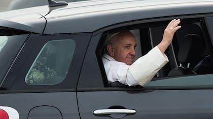 Como una estrella de rock, Francisco saluda desde el automóvil al llegar a Filadelfia ayer. Un modesto Fiat negro