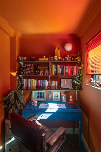 Complementarios, el ‘Naranja Pekín’ (Alba) acompaña el azul ‘Danube’ (Sherwin- Williams) del escritorio estilo Luis XV. Silla ‘Lobby’ de Herman Miller en cuero marrón