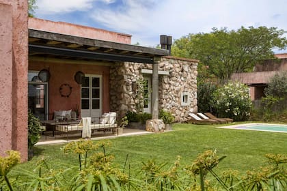 Con acceso desde el comedor, el living y la suite principal, la galería se ambientó con camastros de hierro gastado (La Casita Albarellos) y una mesa ratona en hierro y madera (Alma Muebles).