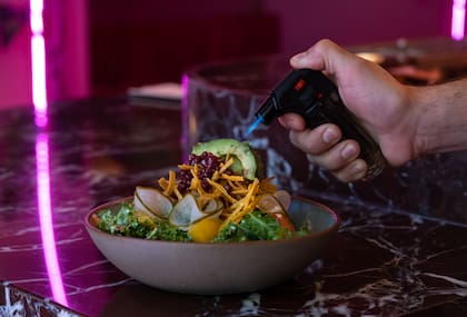 Con cítricos y granada, esta ensalada propone un mix de hojas verdes, gajos de naranja y pomelo, pepino encurtido, palta tatemada, tomates cherry, vinagreta de lima y oliva y tortillas de maíz para un toque crocante.